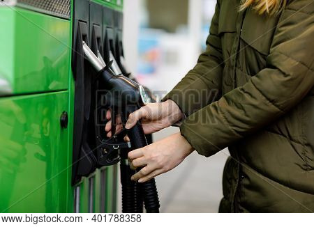 Close-up Of Hands Of Woman At Self-service Gas Station, Hold Fuel Nozzle And Refuel The Car With Pet