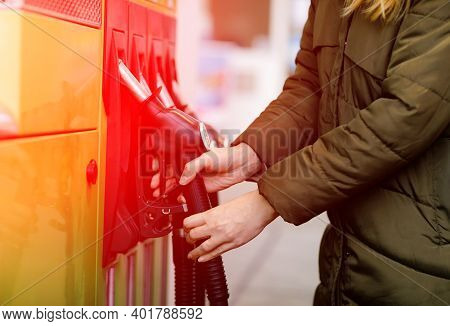 Close-up Of Hands Of Woman At Self-service Gas Station, Hold Fuel Nozzle And Refuel The Car With Pet