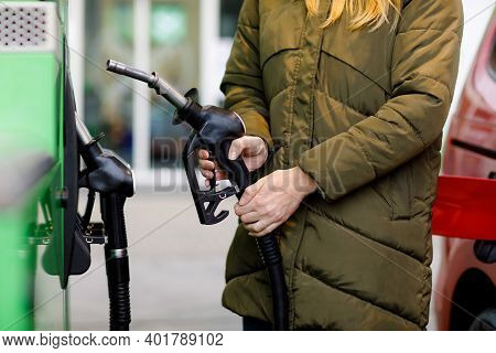 Close-up Of Hands Of Woman At Self-service Gas Station, Hold Fuel Nozzle And Refuel The Car With Pet