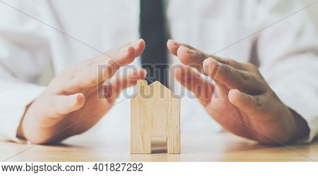 Insurance House And Save Money For Property Investment Real Estate Concept. Man Hands Prevent Wooden