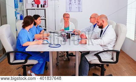 Medical Women Practitoner Writing Notes On Clipboard Wearing Blue Uniform During Conference With Cow