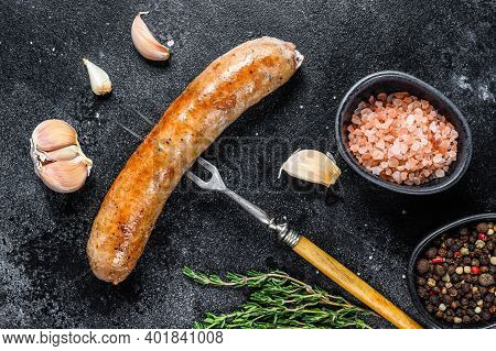 Pork Sausage Bbg Grilled With And Herbs On A Meat Fork. Top View. Black Background