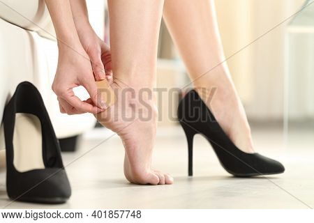 Close Up Of A Woman Foot In Highheels Putting A Plaster On Her Heel At Home