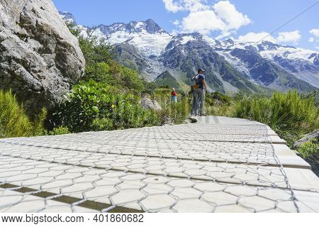 Mount Cook New Zealand - February 16 2015; Tourists Stop To Look At View On Wooden Walkway On Hooker