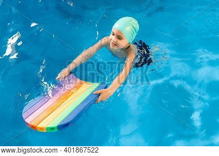 Swimming Class. Close Up Of Kids Practicing Flutter Kick With Kick Board In Swimming Pool