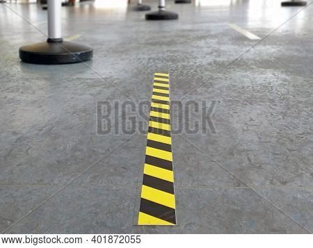 Yellow And Black Passage And Space Delimiting Strip On Gray Ground. Covid 19 Prevention Self-adhesiv