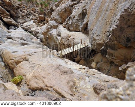 Aerial View Of A Wooden Suspension Bridge To Bridge The Gap Between Rock Formations. Hanging Structu
