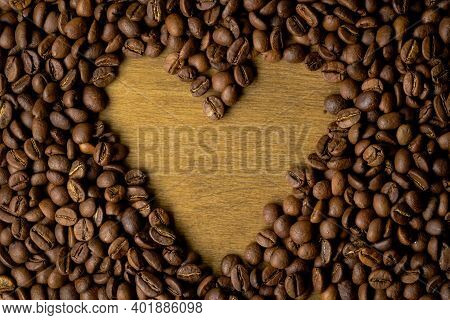 Coffee Beans Background. Fried Coffee On Grunge Wooden Background.