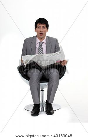 En förstummad affärsman som läser tidningen.