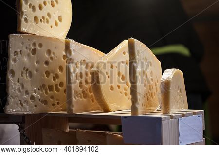 Slices Of French And Swiss Emmental Cheese, Wrapped, With Their Iconic Hole Bubbles, On Display For 
