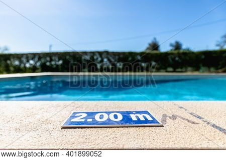 Blue Plastic Plate At The Edge Of A Swimming Pool Indicating A Depth Of 2.00 Meters