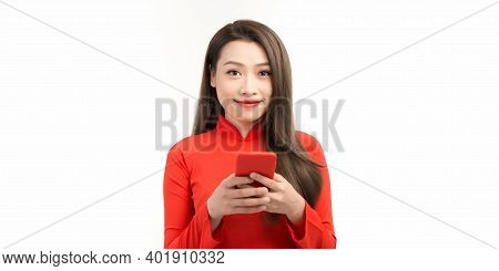 Image Of Happy Beautiful Woman In Red Vietnamese Tranditional Dress, Holding Smartphone.