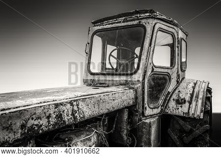 Old Rusty Broken Rural Tractor Stands In The Backyard. Black And White Photo.