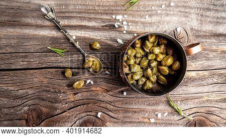 Pickled Capers On A Dark Wooden Background. Edible Flower Buds Of Capparis Spinosa, Caper Bush Or Fl