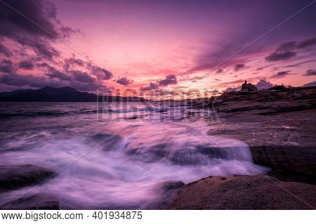 Beautiful Sunset Over An Ancient Genoese Tower As Waves Crash Onto The Rocky Coastline At Punta Cald
