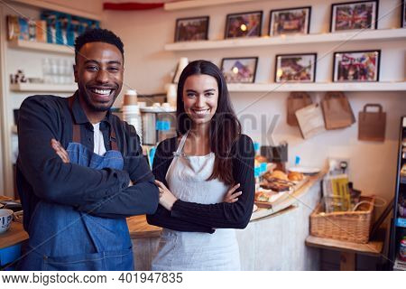 Portrait Of Smiling Couple Running Coffee Shop Together Standing Behind Counter