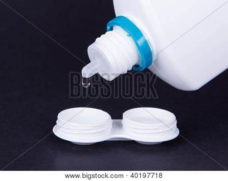 Lens Casing And Bottle Of Water Isolated On Black