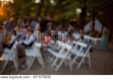 People Are Watching A Concert Of Classical Music. Blurred Young And Adult Women And Men And Other Pe