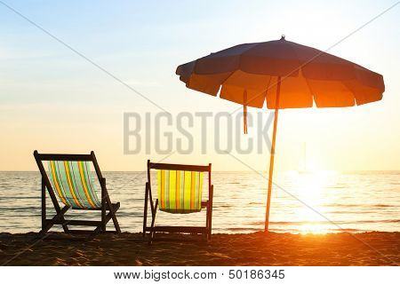 Paar Strand Liegestühle auf einsame Küste Meer bei Sonnenaufgang