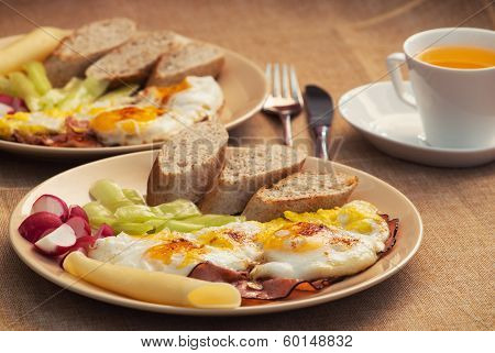 Two Portions Of Ham And Eggs With Bread, Radish, Cheese And Paprika