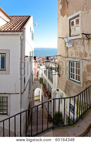 One of the narrow streets of Alfama with the typical cobblestone staircases (Beco da Corvinha). Alfama, Lisbon, Portugal