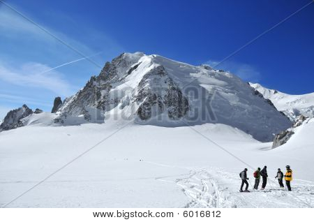 Un gruppo di sciatori, una montagna alta e un grande ghiacciaio