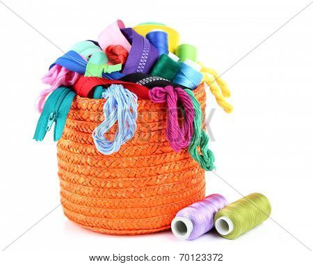 Round orange box full of multicoloured threads and everything necessary for sewing on white background isolated