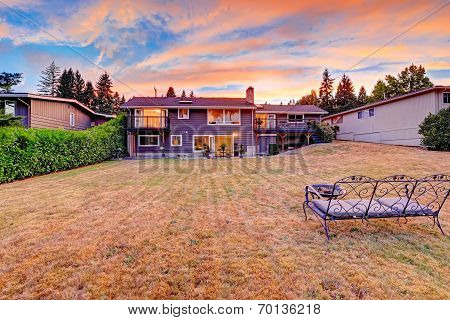 Backyard With Cozy Bench And Fire Pit Overlooking Scenic Sky During Sunset