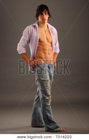 Jovem macho semi-nua muito Muscular permanente em uma camisa