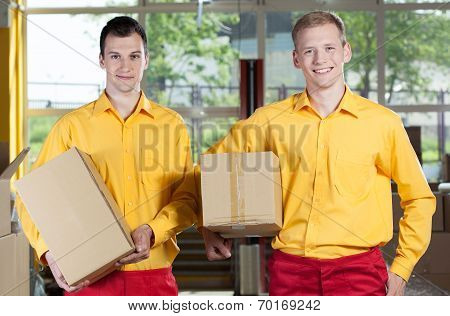 Storekeepers Holding Boxes In Warehouse