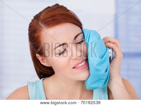 Woman Touching Cheek With Hot Water Bag