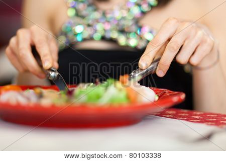 Woman eating in a restaurant closeup