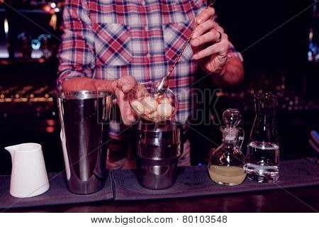 Bartender is making a cocktail with leechee, toned image