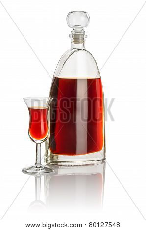 Carafe and high stem glass filled with brown liquid