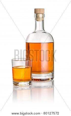 Bottle and drinking glass filled with amber liquid