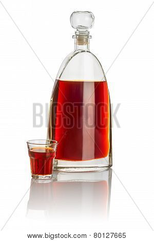 Carafe and beveled shot glass filled with brown liquid