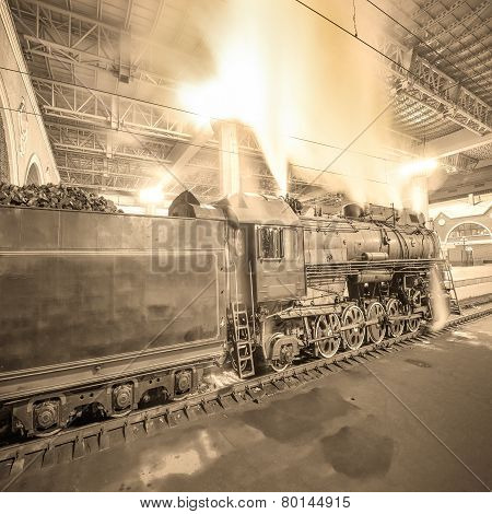 Steam Train Arrives To The Station At Night Time.