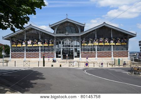 ANGOULEME, FRANCE - JUNE 26, 2013: Man in wheelchair in front of the covered market. Made of architectural glass and iron in 1886, the building is a national historic monument