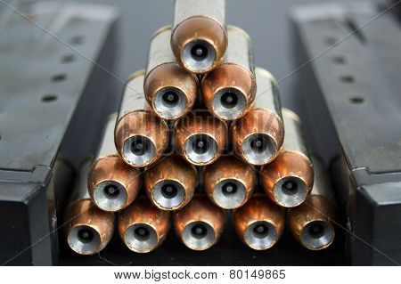 Hollow Point, Copper Jacketed Bullets Stacked In A Pyramid Between Two Magazines