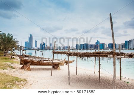 Sea Beach With Old Wooden Boath And Luxury Skyscarper