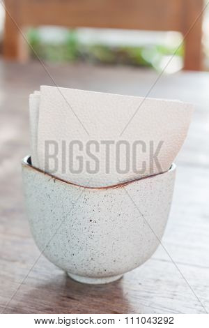 Tissue Paper In Ceramic Cup On Wooden Table