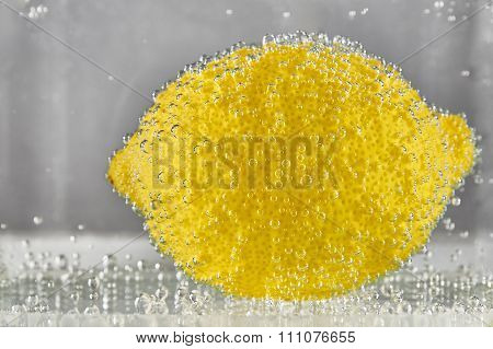 Beautiful Lemon In Water With Bubbles Of Gas
