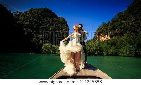 Groom Blonde Bride In Fluffy Stand On Nose Of Longtail Boat