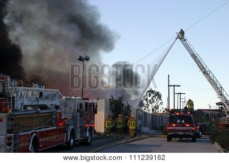 HARBOR GATEWAY, CALIFORNIA- DECEMBER 12, 2015: Fire erupts at recycling yard in Harbor Gateway. Dozens of Fire Trucks arrive to help extinguish an industrial fire, California Dec. 12, 2015 
