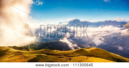 View of the foggy Val di Fassa valley. National Park. Dolomites (Dolomiti), pass Sella. South Tyrol. Location famous resort Canazei, Campitello, Mazzin. Italy, Europe. Dramatic scene. Beauty world.
