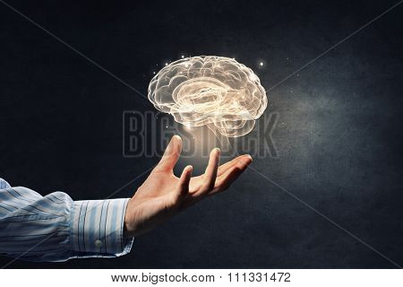 Close up of human hand holding brain symbiol