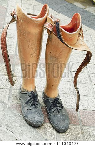 Old prosthetic legs set on a cement floor