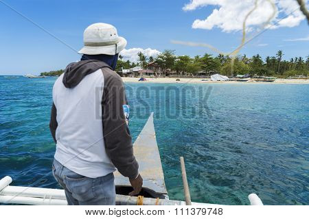 Arrival to tropical island by boat with boatman