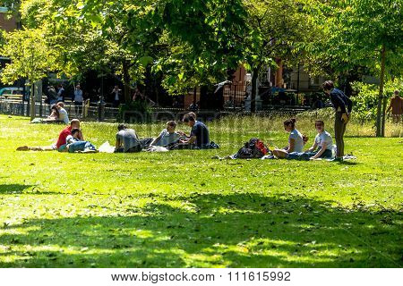 Young People Is Resting On The Grass  St. James Park In London.