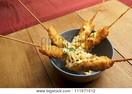 Chicken brochettes bowl with sauce.
